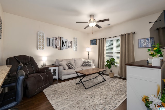 living area featuring dark wood finished floors, visible vents, and ceiling fan