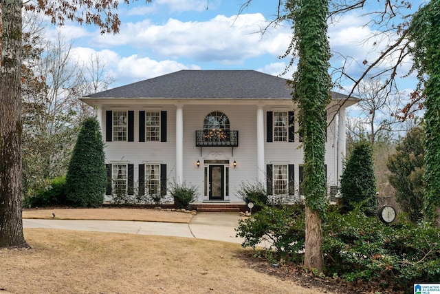 view of front of house featuring a balcony and a shingled roof