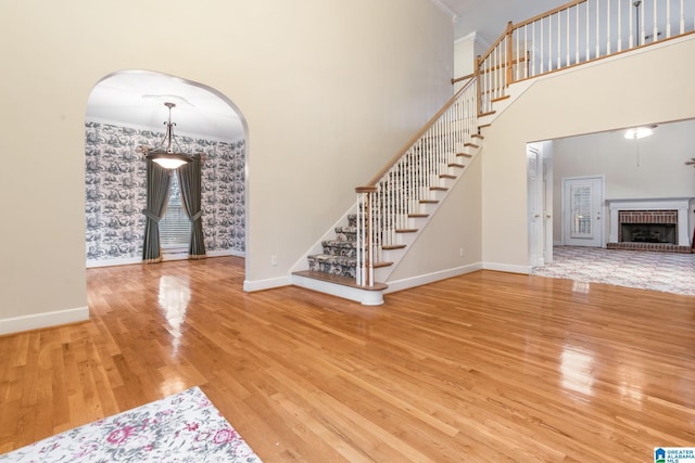 interior space featuring stairway, baseboards, arched walkways, and wood finished floors