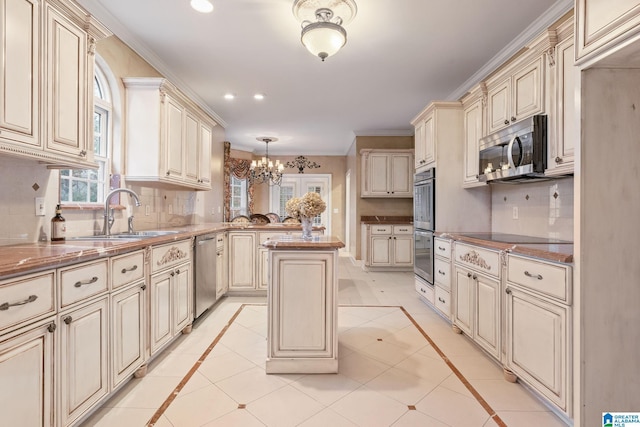 kitchen with a sink, decorative backsplash, cream cabinets, and appliances with stainless steel finishes