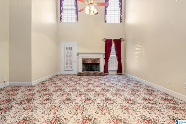 unfurnished living room with baseboards, carpet floors, and a ceiling fan