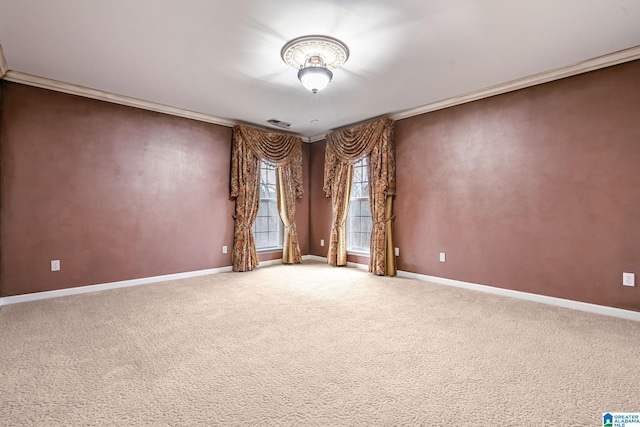 spare room with visible vents, baseboards, crown molding, and carpet