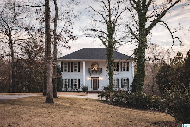 view of front of home featuring a balcony and a front yard