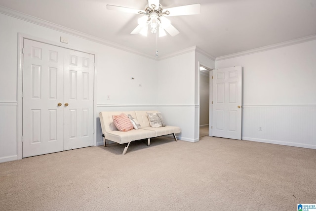 sitting room with ornamental molding, ceiling fan, and carpet floors