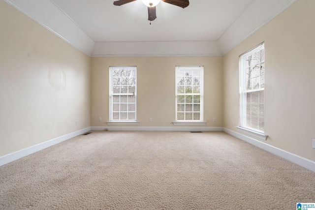 spare room featuring visible vents, baseboards, light colored carpet, lofted ceiling, and a ceiling fan