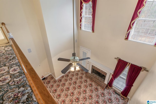 details featuring a glass covered fireplace, baseboards, and a ceiling fan