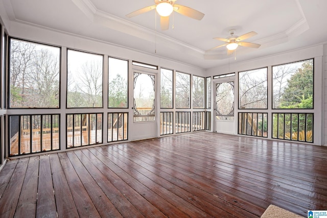 unfurnished sunroom with a tray ceiling and a ceiling fan