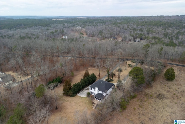 drone / aerial view with a wooded view