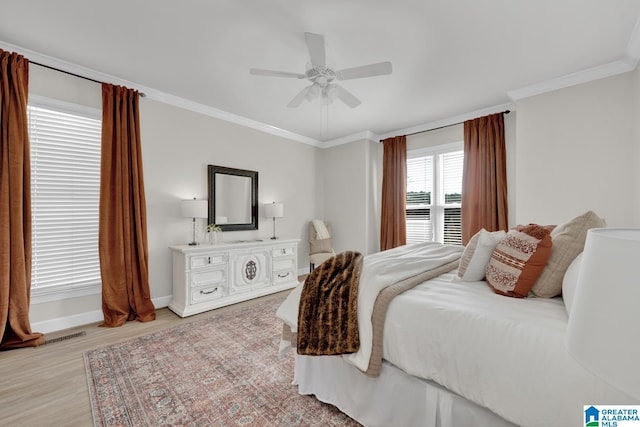 bedroom with visible vents, baseboards, ceiling fan, ornamental molding, and light wood-type flooring