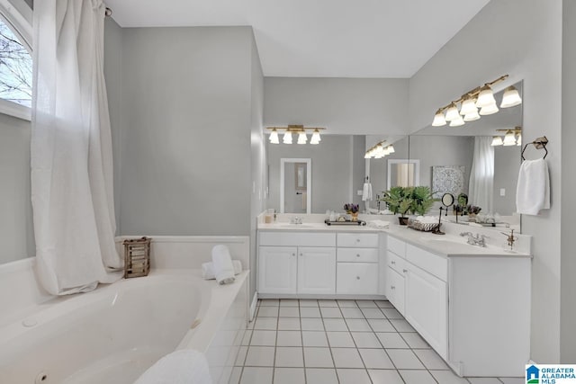 bathroom featuring tile patterned floors, a bath, double vanity, and a sink