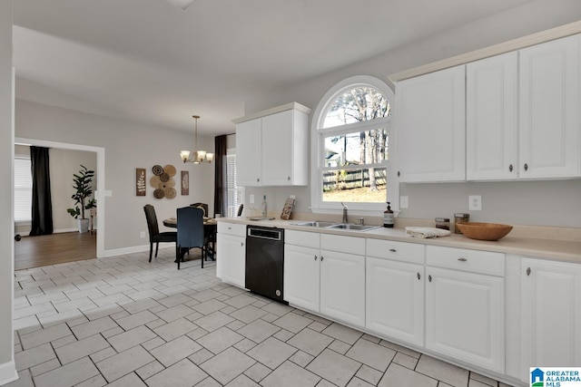 kitchen featuring a sink, hanging light fixtures, light countertops, black dishwasher, and a chandelier