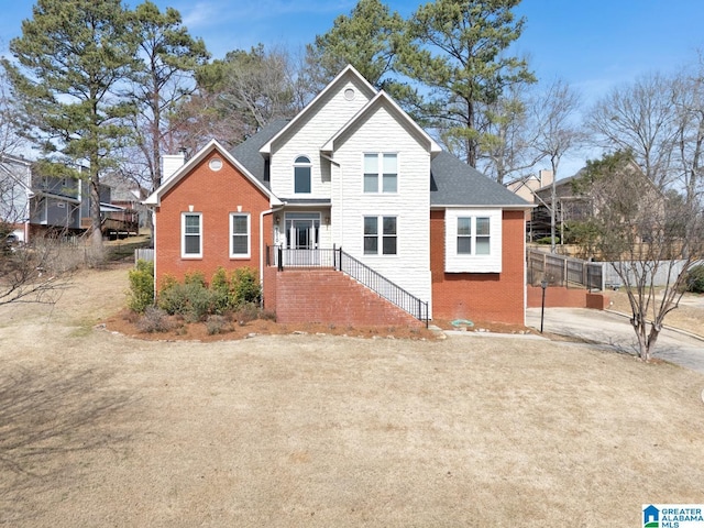 view of front of property with fence, brick siding, and a chimney