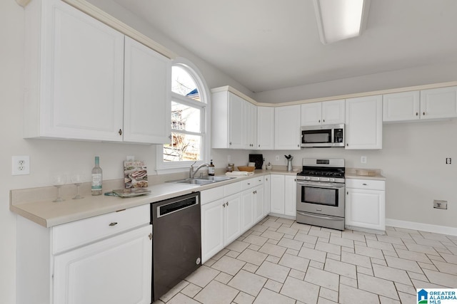 kitchen with a sink, stainless steel appliances, light countertops, and white cabinetry