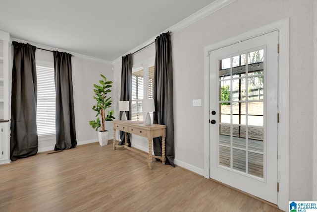 entryway with baseboards, light wood-type flooring, and ornamental molding