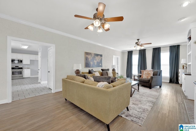 living area with light wood-style flooring, ornamental molding, and ceiling fan