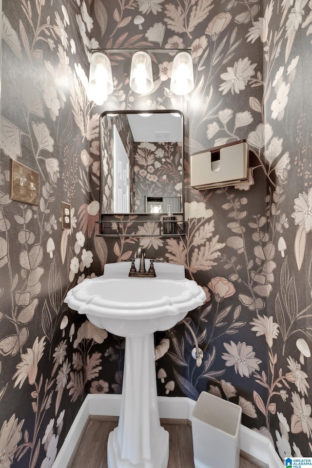 bathroom featuring wallpapered walls, wood finished floors, and baseboards