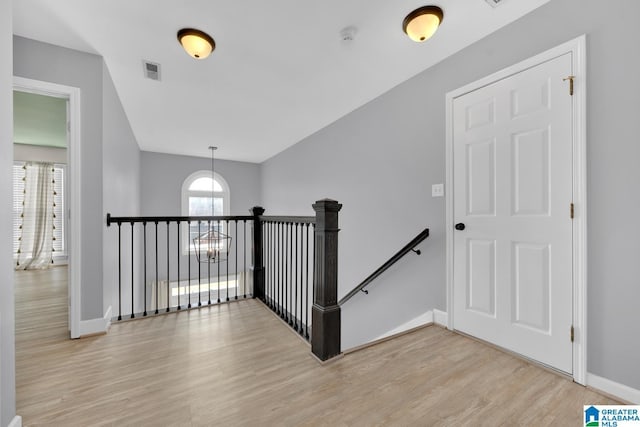 staircase featuring visible vents, baseboards, and wood finished floors