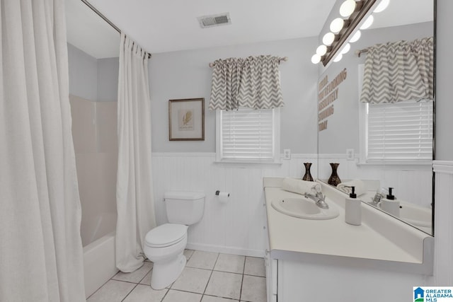 full bathroom featuring vanity, visible vents, a wainscoted wall, tile patterned floors, and toilet