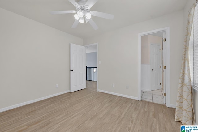 unfurnished bedroom with light wood-type flooring, baseboards, and ceiling fan