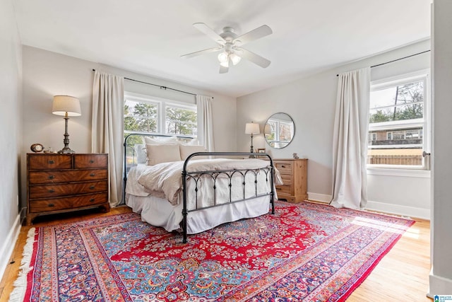 bedroom with ceiling fan, baseboards, and wood finished floors