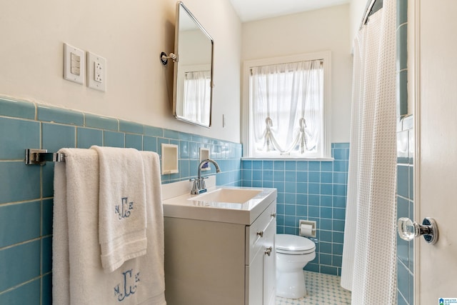 full bath with vanity, wainscoting, curtained shower, tile walls, and toilet