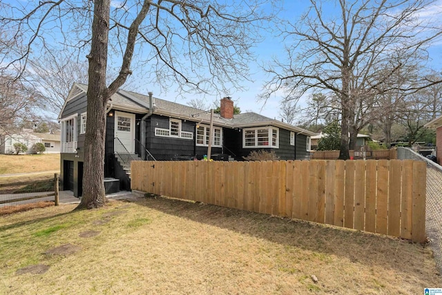 view of front facade featuring a front lawn, a fenced front yard, and a chimney