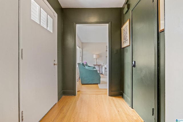 hallway featuring baseboards and light wood-type flooring