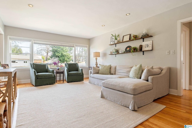 living room featuring recessed lighting, baseboards, and light wood-type flooring