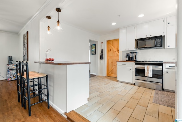 kitchen with crown molding, black microwave, decorative backsplash, electric stove, and white cabinetry