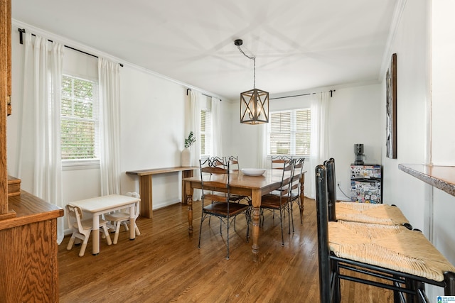 dining space with a wealth of natural light, crown molding, and wood finished floors