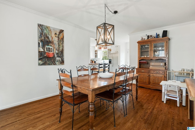 dining space featuring baseboards, dark wood-style flooring, and crown molding