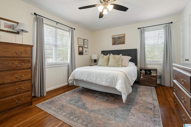 bedroom with a ceiling fan, baseboards, and dark wood-style flooring