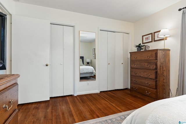 bedroom featuring two closets and dark wood-style floors