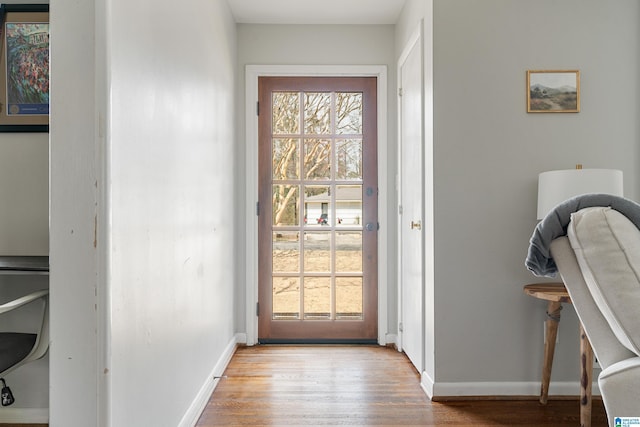 doorway with baseboards and wood finished floors