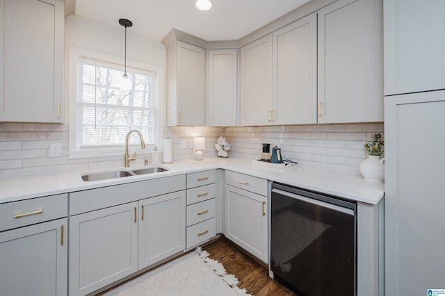 kitchen featuring pendant lighting, dark wood-style flooring, backsplash, and a sink