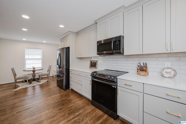 kitchen with backsplash, dark wood finished floors, recessed lighting, stainless steel appliances, and light countertops