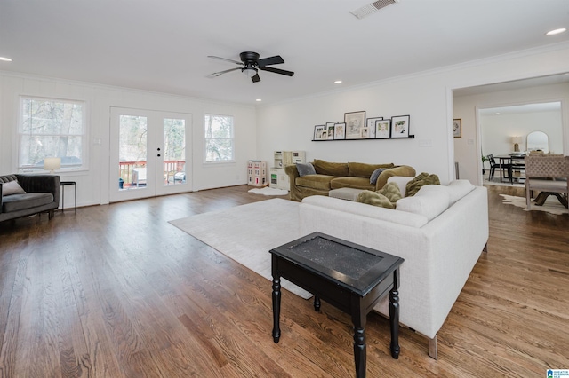 living area with visible vents, ornamental molding, a ceiling fan, wood finished floors, and french doors