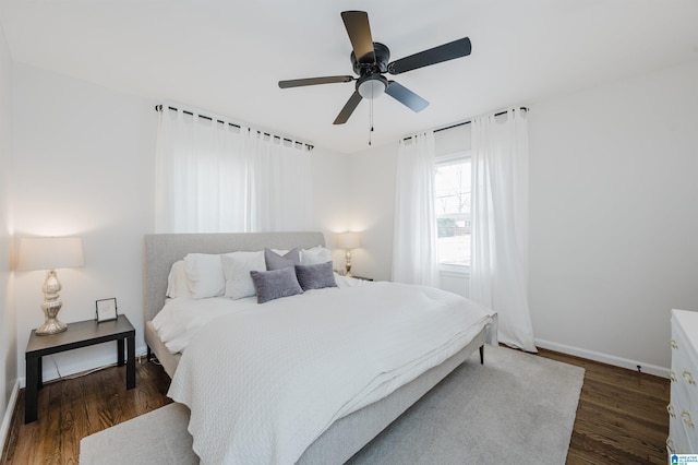 bedroom with ceiling fan, baseboards, and wood finished floors