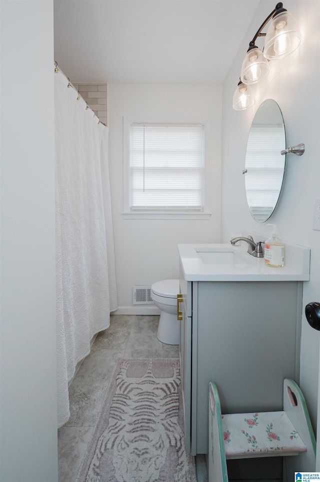 bathroom featuring vanity, toilet, and visible vents