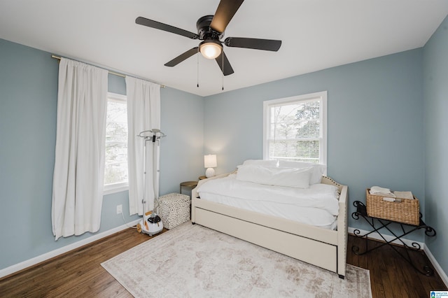 bedroom with a ceiling fan, baseboards, and wood finished floors