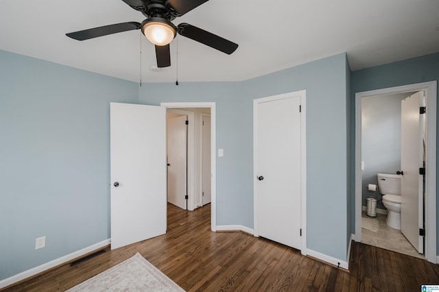 bedroom with visible vents, ensuite bathroom, wood finished floors, baseboards, and ceiling fan