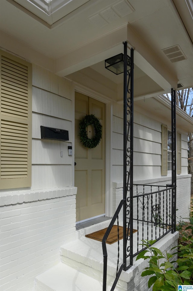 entrance to property with brick siding and visible vents