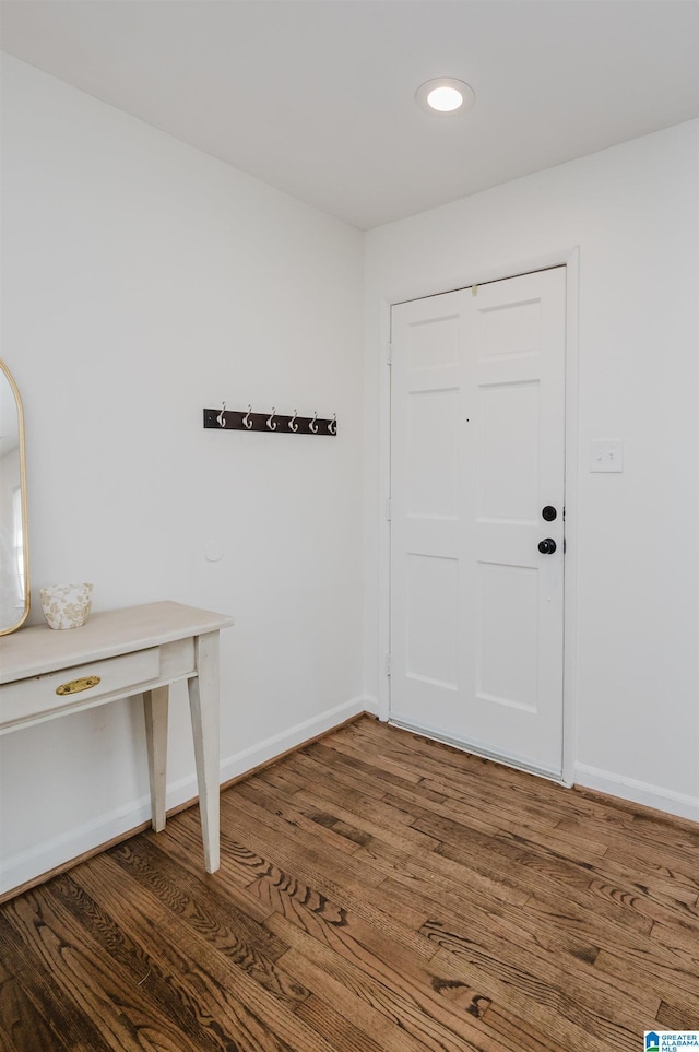 foyer with baseboards and wood finished floors