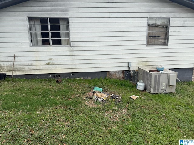 view of property exterior with crawl space, cooling unit, and a yard