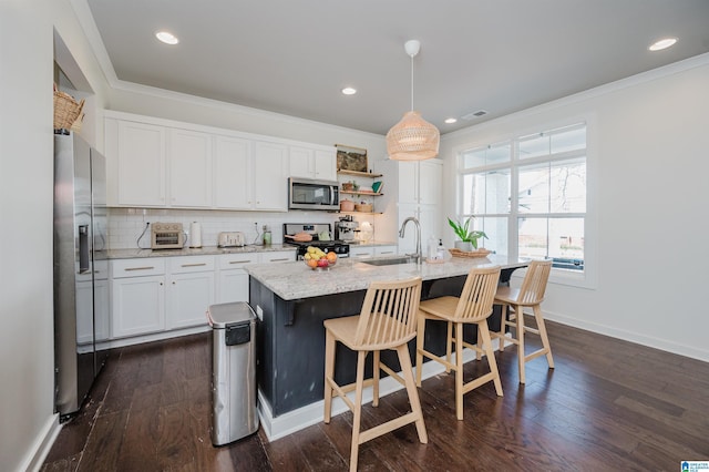 kitchen with tasteful backsplash, ornamental molding, appliances with stainless steel finishes, and a sink