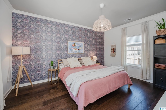 bedroom with visible vents, baseboards, hardwood / wood-style floors, and wallpapered walls