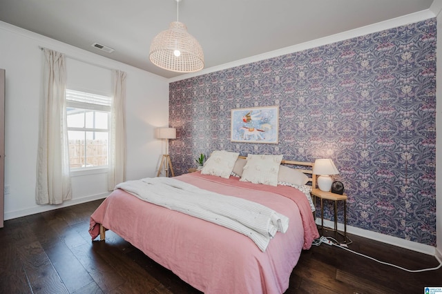 bedroom featuring wallpapered walls, visible vents, baseboards, and hardwood / wood-style floors