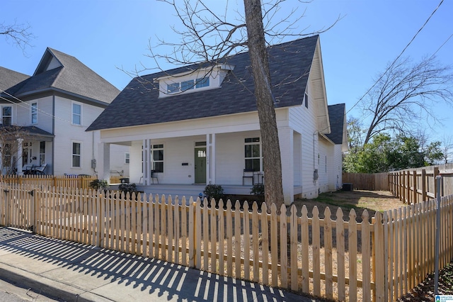 view of front of home featuring a fenced front yard, a porch, roof with shingles, and a gate