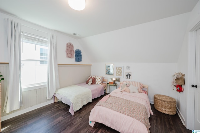 bedroom with vaulted ceiling, visible vents, and wood finished floors