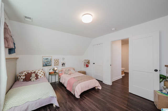 bedroom featuring visible vents, lofted ceiling, and wood finished floors